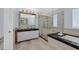 Luxurious bathroom featuring a glass shower, soaking tub, marble countertops, and modern fixtures at 3171 Biccari Ave, Henderson, NV 89044