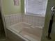 Bathroom featuring a bathtub, tiled walls, grab bars and window at 3261 Winery Rd, Pahrump, NV 89048