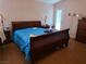 Bedroom with wood floors, a blue covered bed, lamps and dresser at 3261 Winery Rd, Pahrump, NV 89048