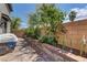Outdoor patio area with lush green foliage and brick retaining wall, perfect for relaxation at 3707 Paseo De Paz Ave, Las Vegas, NV 89115
