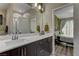 This bright bathroom offers dual sinks with dark wood cabinets and access to the bedroom at 3707 Paseo De Paz Ave, Las Vegas, NV 89115