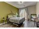This cozy bedroom features a metal frame bed, wood floors and natural light from the sliding glass doors at 3707 Paseo De Paz Ave, Las Vegas, NV 89115