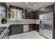 Stylish kitchen featuring stainless steel appliances, dark cabinetry, and a bright window over the sink at 3707 Paseo De Paz Ave, Las Vegas, NV 89115