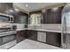 Bright kitchen with stainless steel appliances, dark wood cabinets, and a view of the open living space at 3707 Paseo De Paz Ave, Las Vegas, NV 89115