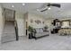 Spacious living room with stairs, a ceiling fan, an open layout, and neutral tile flooring at 3707 Paseo De Paz Ave, Las Vegas, NV 89115