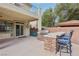 Outdoor covered patio with full kitchen, barstool seating and view of upper floor balcony at 4042 Keefe Falls Ct, North Las Vegas, NV 89085