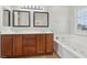 Bathroom with double vanity, soaking tub with white trim, and tiled floors at 4042 Keefe Falls Ct, North Las Vegas, NV 89085