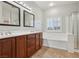 Bathroom with double vanity, soaking tub with white trim, and tiled floors at 4042 Keefe Falls Ct, North Las Vegas, NV 89085