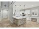 Open kitchen with an island, white cabinets, stainless steel appliances, and modern lighting fixtures at 4042 Keefe Falls Ct, North Las Vegas, NV 89085