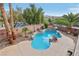 Backyard kidney shaped pool has rock features, lush palm trees, and plenty of patio space at 4042 Keefe Falls Ct, North Las Vegas, NV 89085