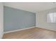 Bright bedroom with blue accent wall, wood flooring, and ample natural light at 4310 Sandy River Dr # 70, Las Vegas, NV 89103