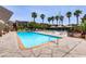 Large community pool surrounded by lounge chairs and mature palm trees on a sunny day at 4310 Sandy River Dr # 70, Las Vegas, NV 89103