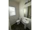 Half bathroom featuring a toilet, pedestal sink, and window providing natural light at 4645 Fuchsia Nights Ave # 103, North Las Vegas, NV 89084
