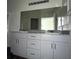 Bathroom with a granite countertop vanity, ample storage, and a large mirror at 4645 Fuchsia Nights Ave # 103, North Las Vegas, NV 89084