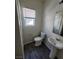 Modern powder room with pedestal sink, wood-look floors, and a window at 4645 Fuchsia Nights Ave # 103, North Las Vegas, NV 89084