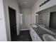 Double sink vanity with granite countertop and framed mirror in a modern bathroom at 4645 Fuchsia Nights Ave # 103, North Las Vegas, NV 89084