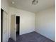 This carpeted bedroom offers a neutral color palette and an open closet ready to be styled at 4645 Fuchsia Nights Ave # 103, North Las Vegas, NV 89084