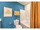 Bathroom with white tiled shower/tub, blue walls, framed art, and checkered towels at 4839 Orchid Ridge Ave # 96, Las Vegas, NV 89141