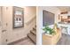 View of staircase with mirror, tv, cabinet, and view of the kitchen with stainless steel appliances and white cabinets at 4839 Orchid Ridge Ave # 96, Las Vegas, NV 89141