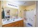 Well-lit bathroom with a white tiled shower and tub combination and a functional vanity with counter space at 5017 Hadley Meadow Ct, Las Vegas, NV 89131