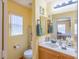Bright bathroom with a window, toilet, and a vanity with a sink and a view into the adjacent bedroom at 5017 Hadley Meadow Ct, Las Vegas, NV 89131