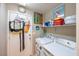Functional laundry room with washer, dryer, shelving and decor at 5017 Hadley Meadow Ct, Las Vegas, NV 89131