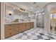 Stylish bathroom with double vanity, marble countertop, glass-enclosed shower, and tiled floors at 5239 Tartan Hill Ave, Las Vegas, NV 89141