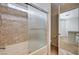 Bathroom with shower over tub, glass enclosure, and decorative stone backsplash at 5239 Tartan Hill Ave, Las Vegas, NV 89141