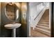 Stylish powder room with pedestal sink and decorative mirror, conveniently located near the staircase at 5239 Tartan Hill Ave, Las Vegas, NV 89141