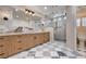 Beautiful bathroom with a marble countertop vanity, large mirror, and glass-enclosed shower at 5239 Tartan Hill Ave, Las Vegas, NV 89141