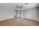 Large bedroom with a ceiling fan, neutral carpet, with entrances to another bedroom and the hall at 5239 Tartan Hill Ave, Las Vegas, NV 89141