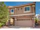 Charming two-story home featuring a two-car garage with a stone archway and manicured landscaping at 5239 Tartan Hill Ave, Las Vegas, NV 89141