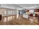 Spacious open-concept living area featuring wood floors, modern lighting, and a seamless flow to the kitchen at 5239 Tartan Hill Ave, Las Vegas, NV 89141