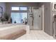 Bright bathroom featuring soaking tub with glass block window and separate glass-enclosed shower at 53 Grossinger Ct, Henderson, NV 89074