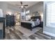 Cozy bedroom with vaulted ceiling, wood-look floors, elegant black furniture, and a view to the ensuite at 53 Grossinger Ct, Henderson, NV 89074