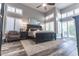 Spacious bedroom with wood floors, ceiling fan, many windows, and stylish black furnishings at 53 Grossinger Ct, Henderson, NV 89074