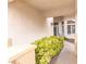 Covered entryway with neutral siding, decorative shrubbery, and a dark gray front door at 53 Grossinger Ct, Henderson, NV 89074
