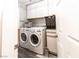 Bright laundry room with white cabinets, modern front loading washer and dryer, and gray plank flooring at 53 Grossinger Ct, Henderson, NV 89074