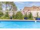 Relaxing swimming pool surrounded by lush greenery, potted plants, and a tiled border at 53 Grossinger Ct, Henderson, NV 89074