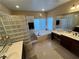 Bright bathroom with a jacuzzi bathtub, dual sinks, and a walk-in glass block shower at 530 Calahonda Ct, Las Vegas, NV 89138
