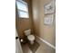 Powder room featuring a commode, neutral paint, and decorative floral artwork at 530 Calahonda Ct, Las Vegas, NV 89138