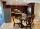 Open-concept kitchen with dark wood cabinetry, stainless steel appliances, and a breakfast nook with a round table at 530 Calahonda Ct, Las Vegas, NV 89138