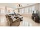 Spacious living room with a sectional sofa, ceiling fan, and large windows with shutters at 5920 Big Horn View St, North Las Vegas, NV 89031