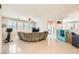 Spacious living room with a sectional sofa, ceiling fan, and large windows with shutters at 5920 Big Horn View St, North Las Vegas, NV 89031