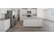 Modern kitchen featuring white cabinets, stainless steel appliances, and a large island with a quartz countertop at 6713 Violet Cascade Ave, Las Vegas, NV 89156