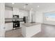 Modern kitchen featuring white cabinets, an island with a sink, stainless steel appliances, and a window at 6736 Lotus Vista Ct, Las Vegas, NV 89156