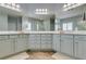 Bright bathroom featuring double vanity, wood floors, modern lighting and framed mirrors at 7349 Royal Melbourne Dr, Las Vegas, NV 89131