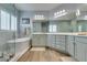 Bright and airy bathroom featuring a soaking tub, a glass shower and dual vanities at 7349 Royal Melbourne Dr, Las Vegas, NV 89131