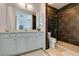 Modern bathroom with a walk-in shower, a vanity and a dark tile accent wall at 7349 Royal Melbourne Dr, Las Vegas, NV 89131