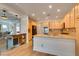 Open kitchen with a large island, wood cabinetry, and hardwood floors extending to dining area at 7349 Royal Melbourne Dr, Las Vegas, NV 89131